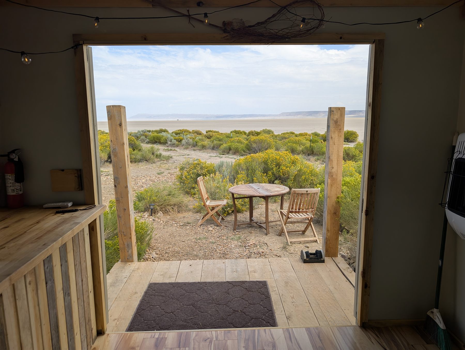 The cabin door open onto the deck and the open desert beyond